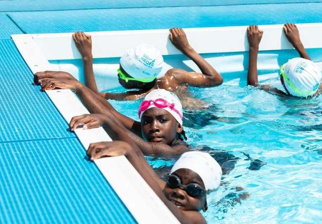 Children learning to swim at the poolside
